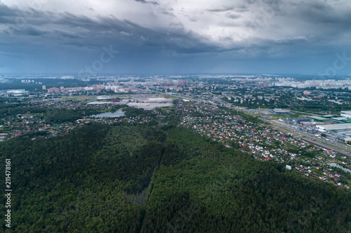 Aerial view of wheat fields, meadow, forest and village in rural Russia.