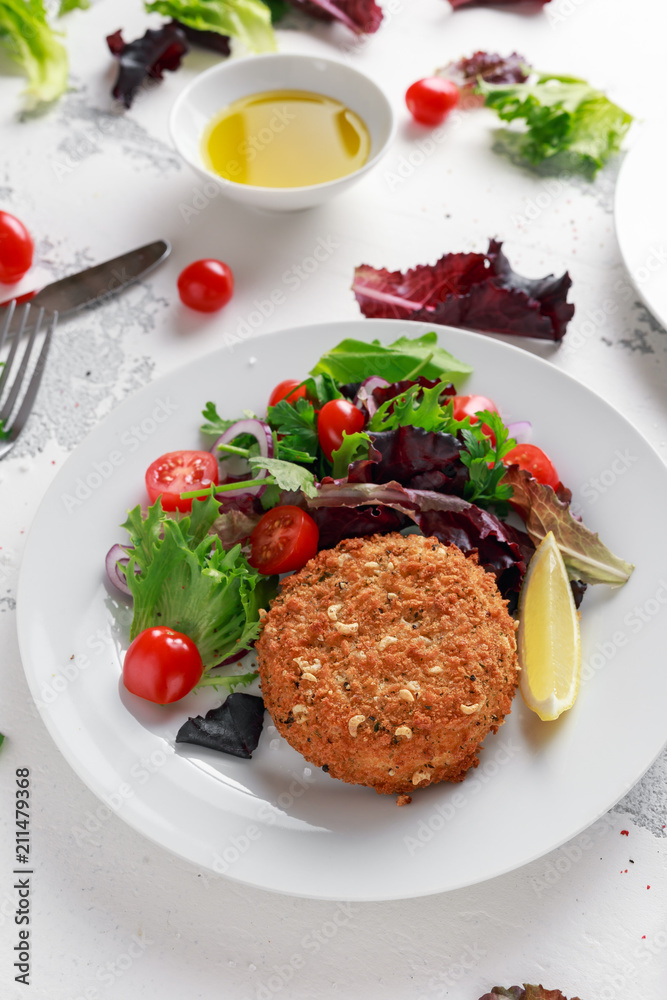 Home made Fish Cake salmon, spinach and potato. served on plate with vegetables Home made Fish Cake salmon, spinach and potato. served on plate with vegetables