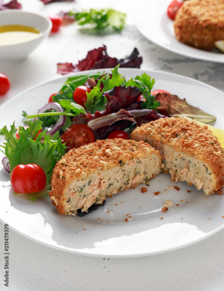 Home made Fish Cake salmon, spinach and potato. served on plate with vegetables Home made Fish Cake salmon, spinach and potato. served on plate with vegetables