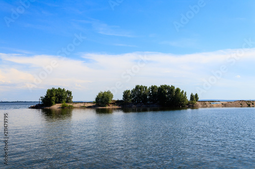 Summer landscape with beautiful lake, green trees and blue sky © olyasolodenko