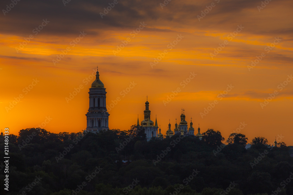 Domes of Lavra Cathedral in Kiev, low angle. Yellow sunset background. Panoramic view.