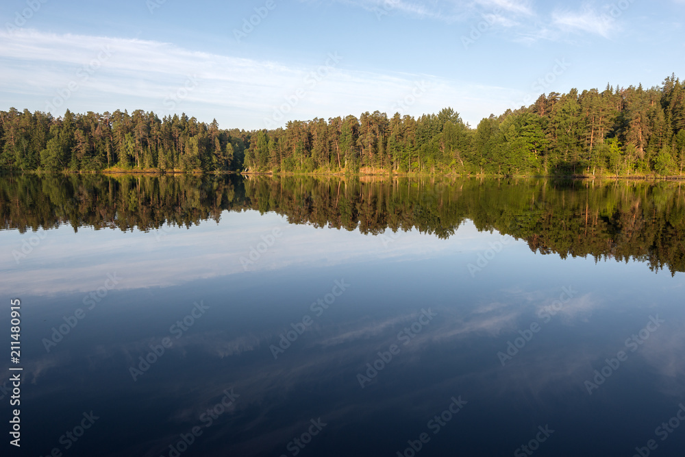 Morning dawn and mirror reflection of the coastline of the island of Valaam. Valaam is a cozy and quiet piece of land, the rocky shores of which rise above the lush waters of lake Ladoga