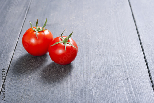 two red tomatoes on old black wood table