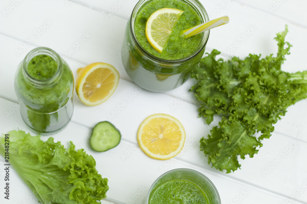 Obraz premium Green smoothies with vegetables, herbs and lemon on a white background. Healthy eating. Vegetarian cocktail.