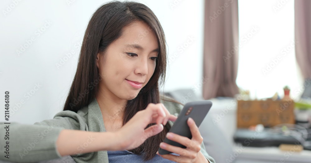 © leungchopan - Housewife using smart phone at home