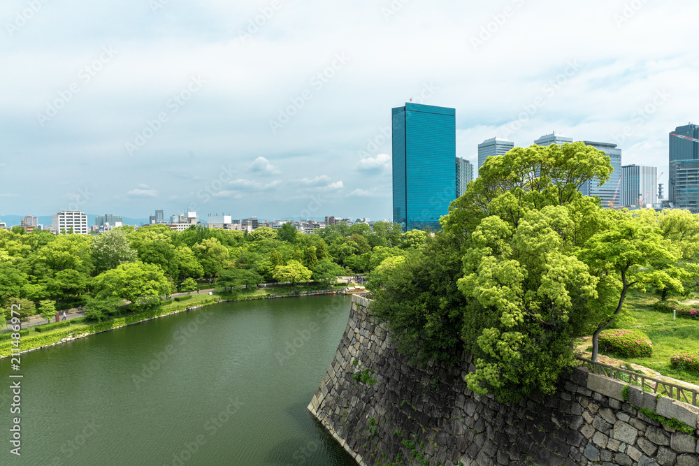 Wall and moat around Osaka Castle and skyscrapers of Osaka Busin