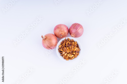 Deep fried shallots crisp / fried crispy onion flakes  (bawang goreng) in white bowl over wooden background.