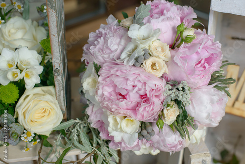 Cropped shot of pale pink hues bouquet featuring peonies, freesias and green leafy accessories, prepared for special occasions, weddings or events, or as a bouquet carried by the bride or bridesmaids