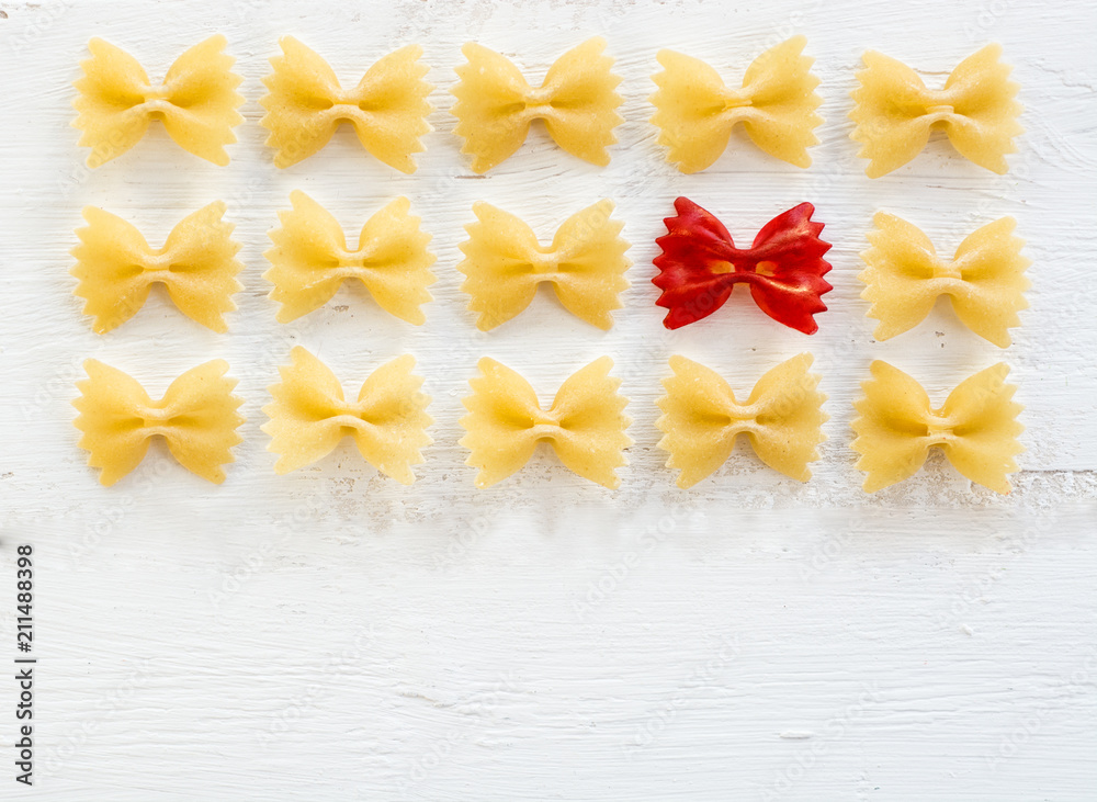 Obraz premium raw Italian pasta Farfalle - abstract vision be different, unique personality or standing out from the crowd, leadership quality. beautiful still life background 