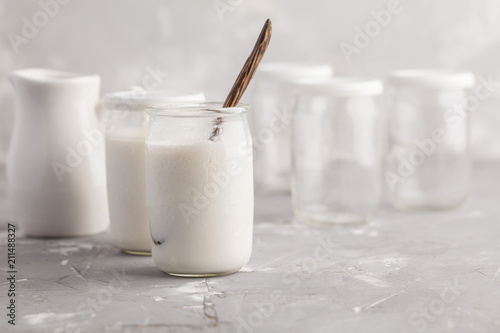 Preparation of homemade yogurt in a glass jar on the table.