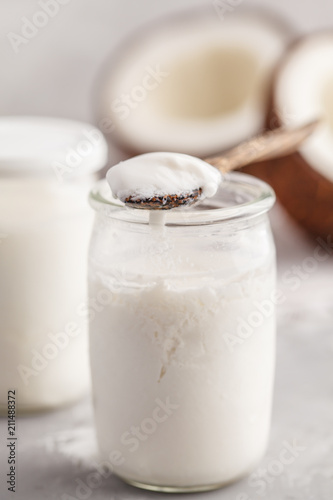 Homemade coconut yogurt in a glass jar on the table. Healthy alternative vegan food concept.