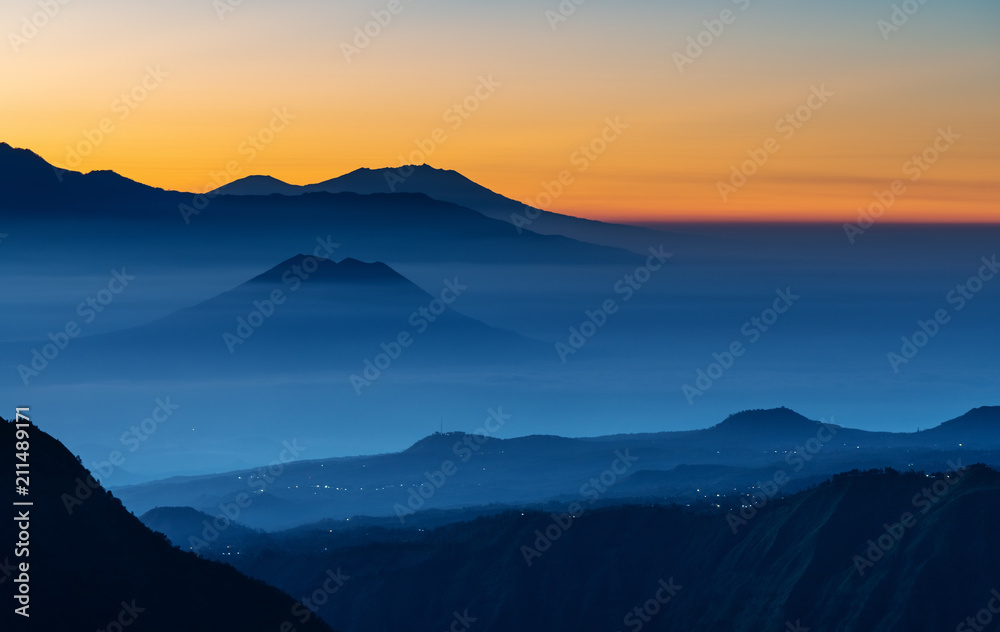 Mountain range landscape and silhouette mountains with colourful fog in sunrise