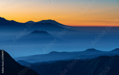 Mountain range landscape and silhouette mountains with colourful fog in sunrise © SasinParaksa