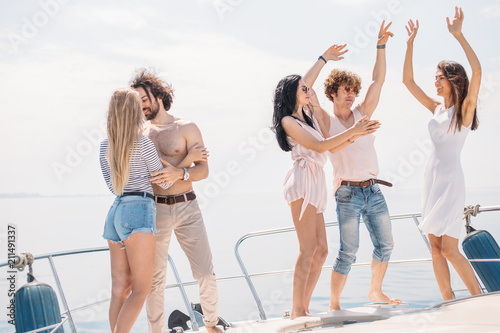 Young yoyful people having fun in boat party - Happy friends enjoying sea trip to islands. Marine Cruise, Travelling and Vacations photo