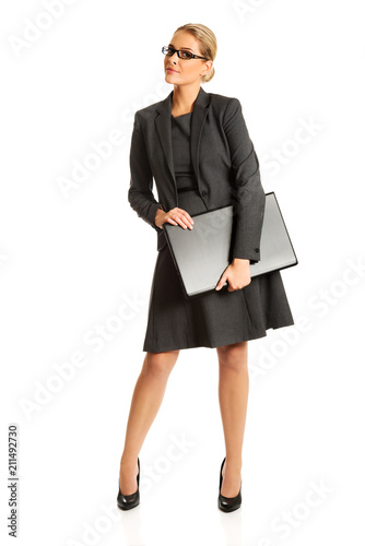 Businesswoman standing and holding a laptop