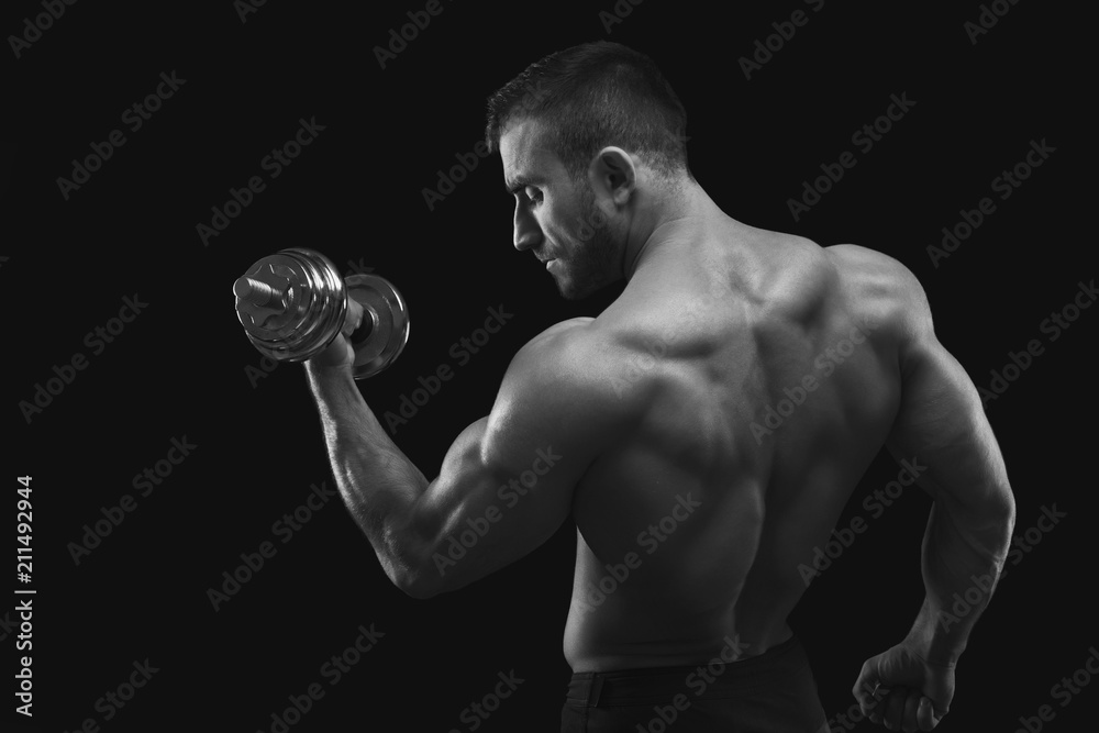Strong man with dumbbell showing muscular body
