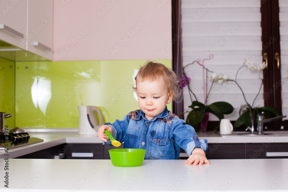 Baby child eats food himself with spoon Baby child eats food himself with spoon