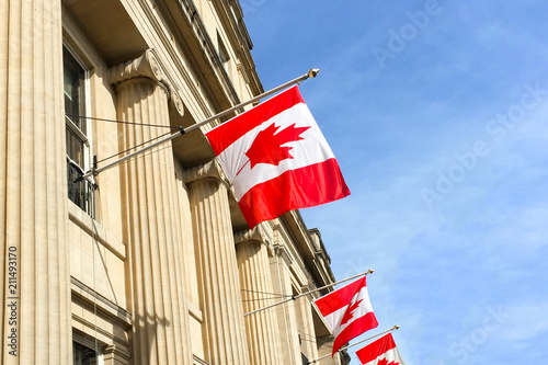 Canadian flags on a building against a blue sky