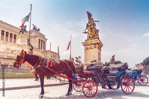 Altare della Patria and Monument to Vittorio Emanuele II on Piazza Venezia with horse drawn carriage in foreground. Italy capital landmarks.