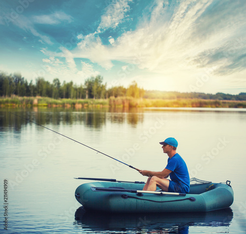 A fisherman in a rubber boat is fishing on the lake