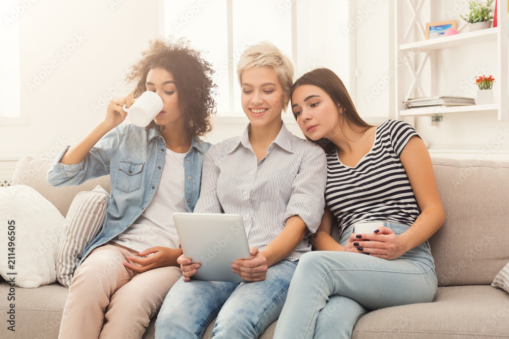 Three friends using tablet and drinking coffee Three friends using tablet and drinking coffee