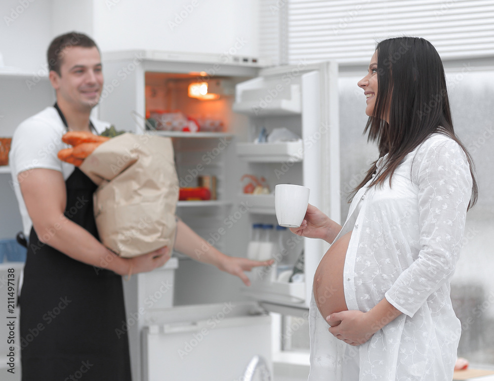 happily married couple .standing in the kitchen happily married couple .standing in the kitchen