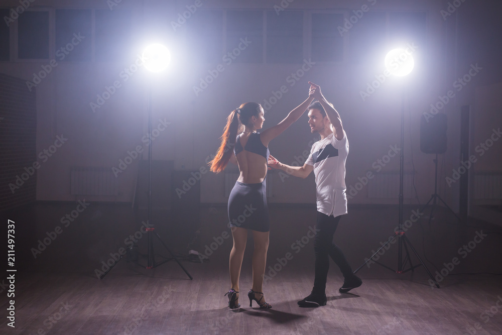 Fototapeta premium Young couple dancing latin dance Bachata, merengue, salsa. Two elegance pose in dance class