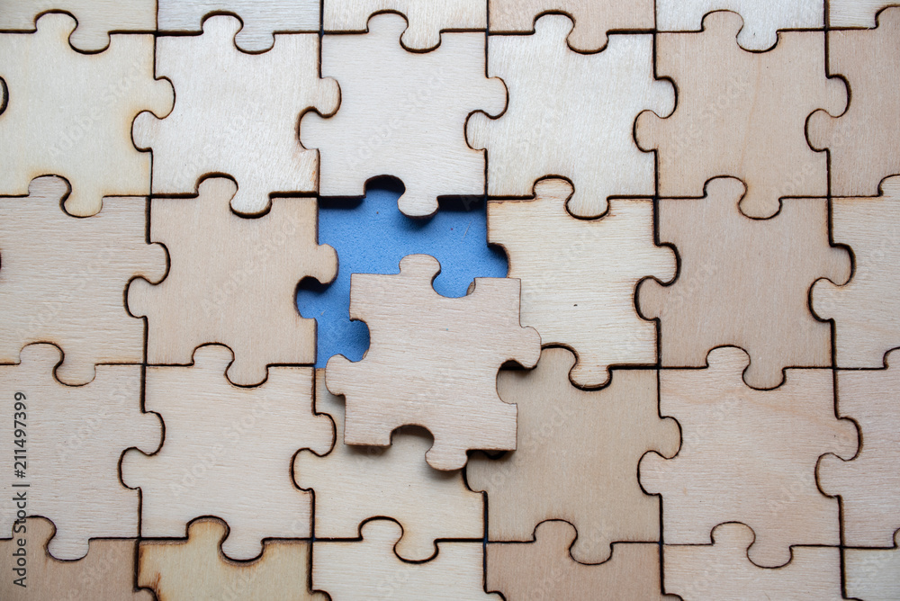 Wood jigsaw puzzle on blue background, business concept Wood jigsaw puzzle on blue background, business concept