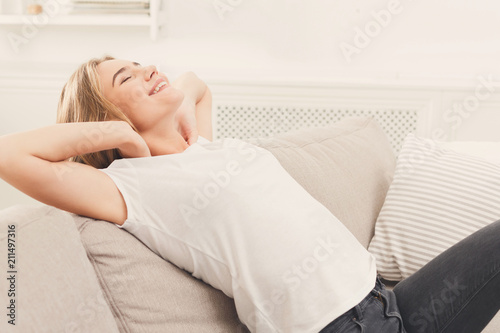 Young happy blomde woman sitting on couch