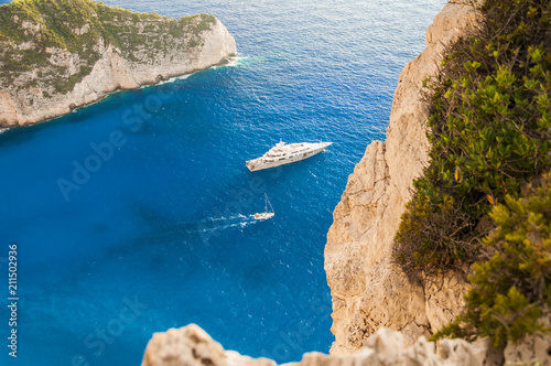 View from above on luxury boat sailing across the beautiful blue sea during summer time. Colorful vacation landscape of cruise around greek island to sightseeing beautiful places.