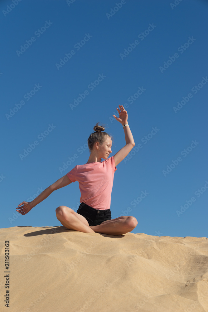 ein junges Mädchen macht Yoga Übungen / Meditation in freier Natur, vor blauem Himmel ein junges Mädchen macht Yoga Übungen / Meditation in freier Natur, vor blauem Himmel