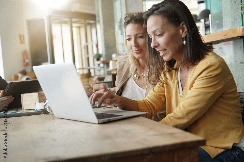 Fototapeta premium Young women working on laptop in coffeeshop