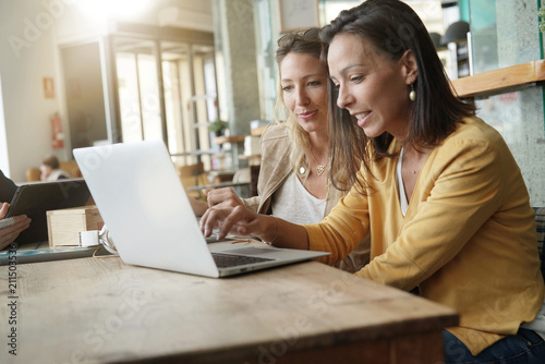 Young women working on laptop in coffeeshop