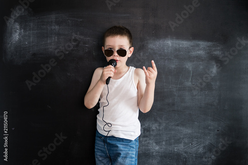 Young boy's standing near blackboard singing in microphone. Rockstar. Creative design concept for 2019 calendar. 