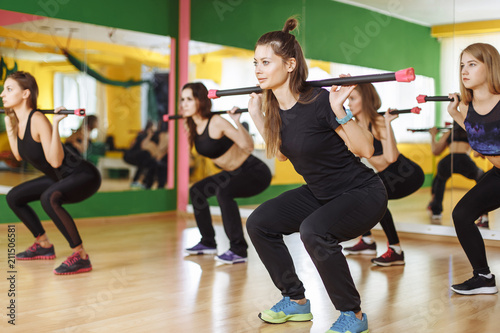 Fitness, sport, training and lifestyle concept - group of women with barbells in gym