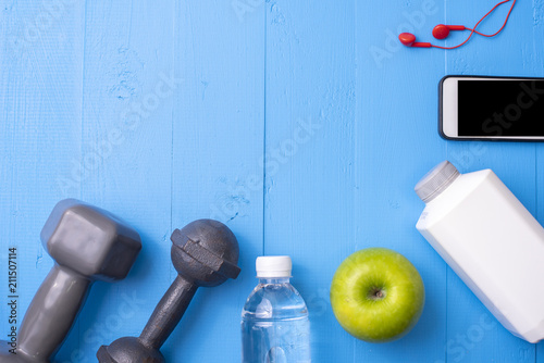 Fitness equipment and Health food on blue wooden background