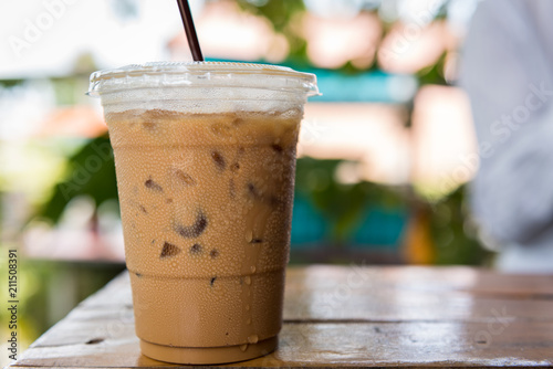 Ice coffee with water drop on wooden table