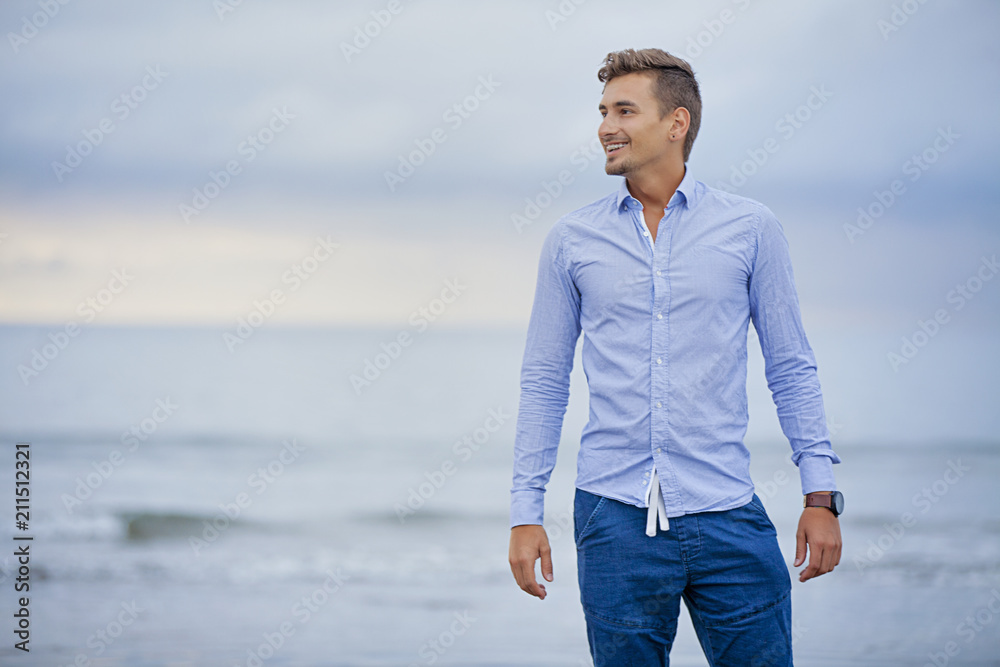 Beautiful casual man with amazing smile. Man on the beach Beautiful casual man with amazing smile. Man on the beach