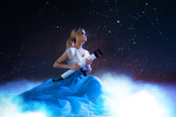Young woman dreams of the future, concept. Girl above the clouds looks up and uses a telescope. Starry sky