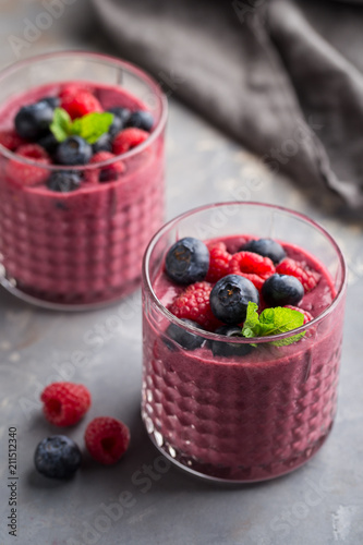 Mixed berry smoothie with mint on concrete background  close up