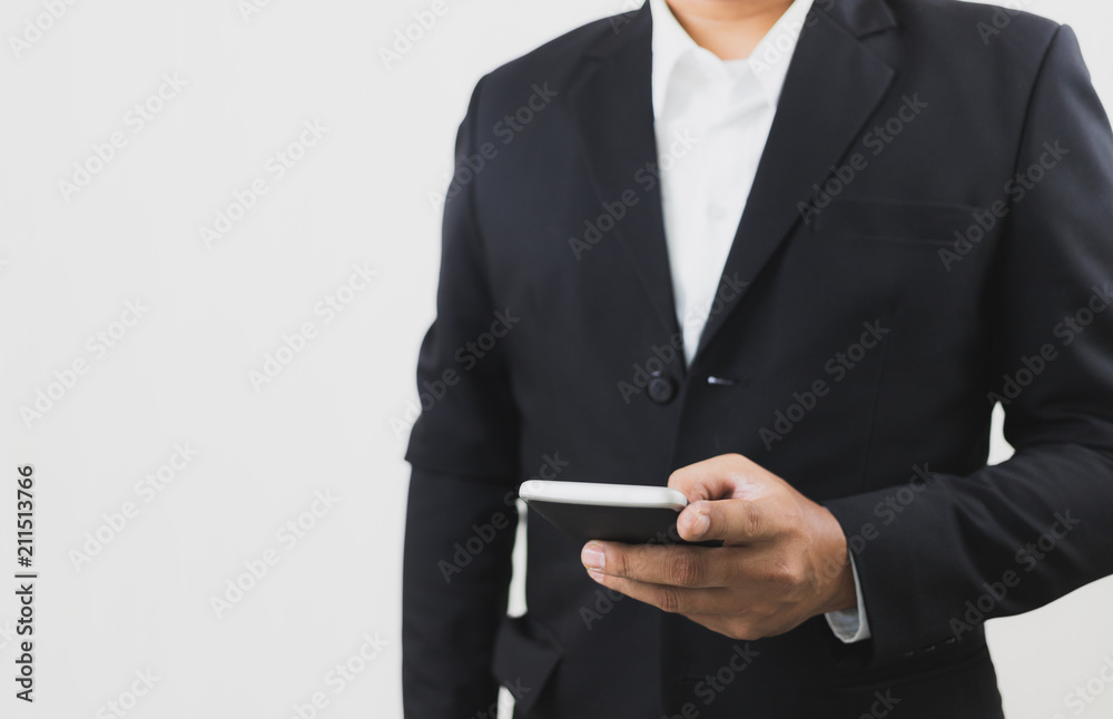 Businessman wear black suit hand holding and touch screen smart phone. Telecommunication and Technology concept. With copy space. Businessman wear black suit hand holding and touch screen smart phone. Telecommunication and Technology concept. With copy space.