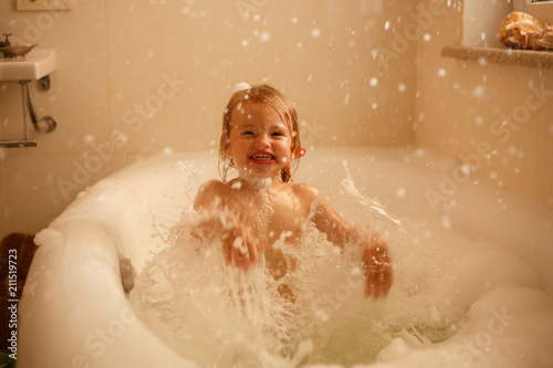 Little girl playing with water in bathroom