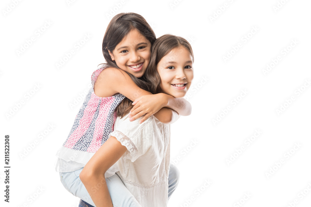 Cute young sister hugging older sister on white background Cute young sister hugging older sister on white background