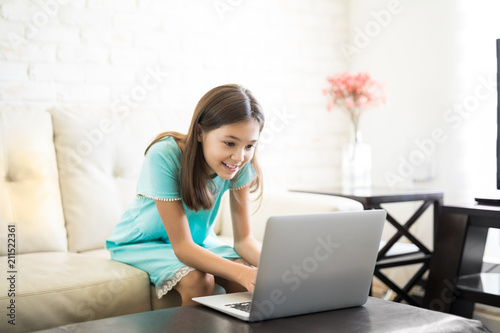 School girl learning with computer and internet indoors