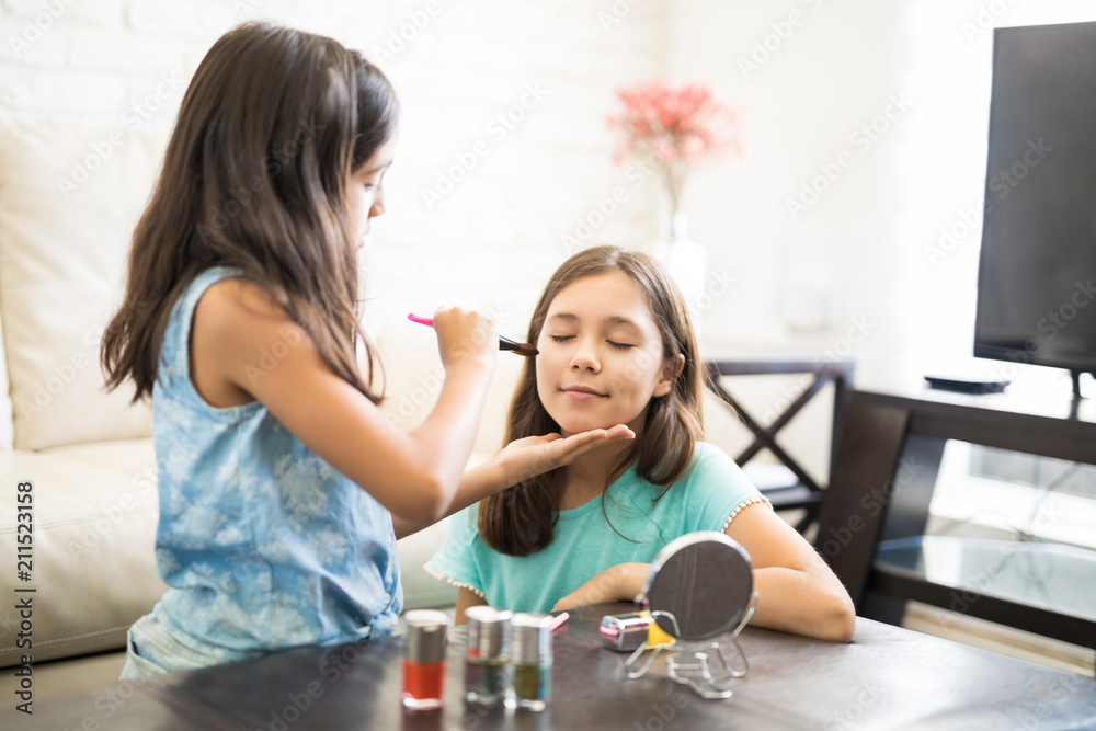 Adorable girls playing with their mommy's cosmetic accessories
