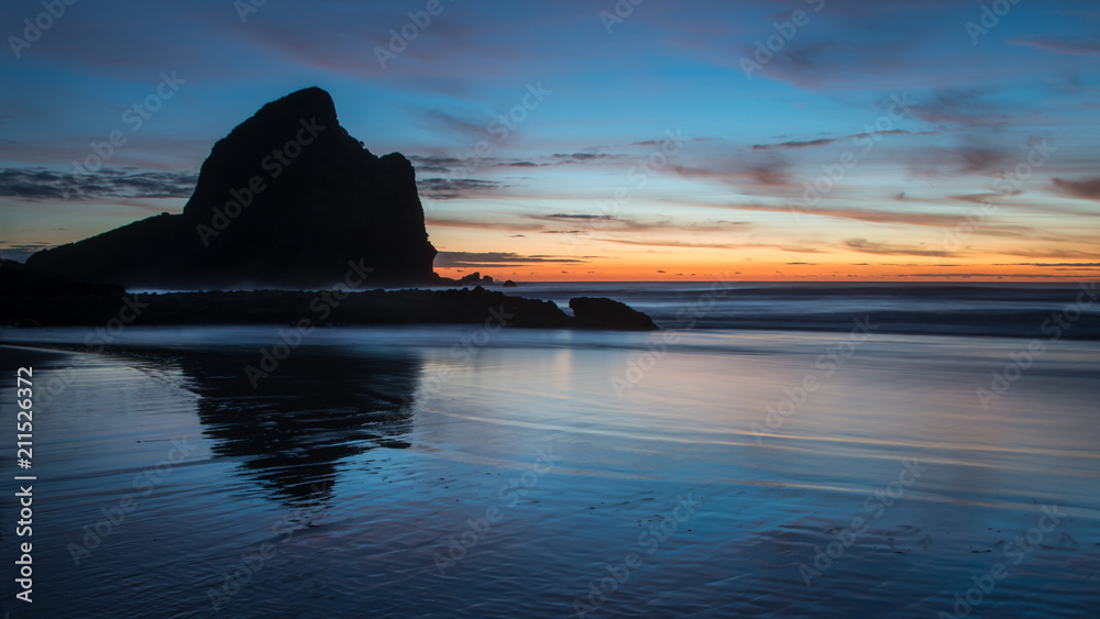 Rocks silhouette at Piha Beach at Sunset, West Auckland