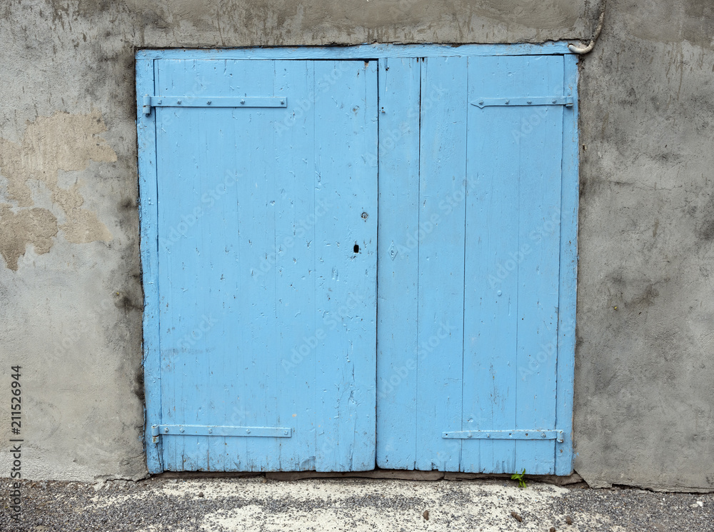 old blue painted closed doors in wall of house in french provence