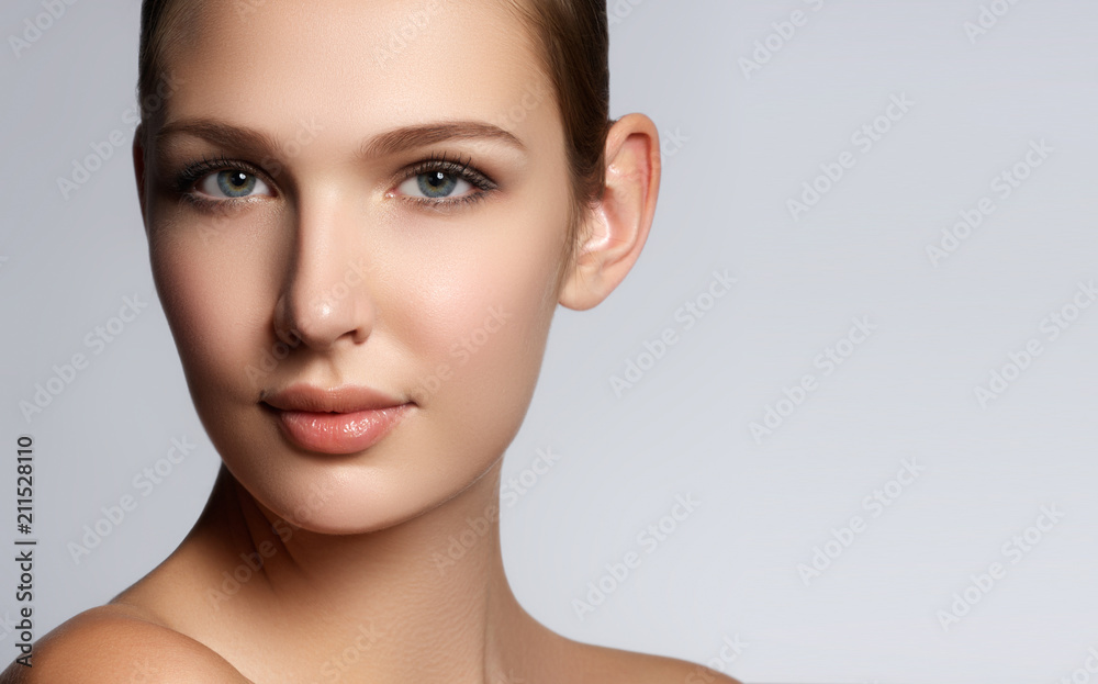 Sexy beauty face. Glamour portrait of beautiful woman model with fresh daily makeup. Fashion shiny highlighter on skin, sexy gloss lips make-up and perfect eyebrows. Natural beauty