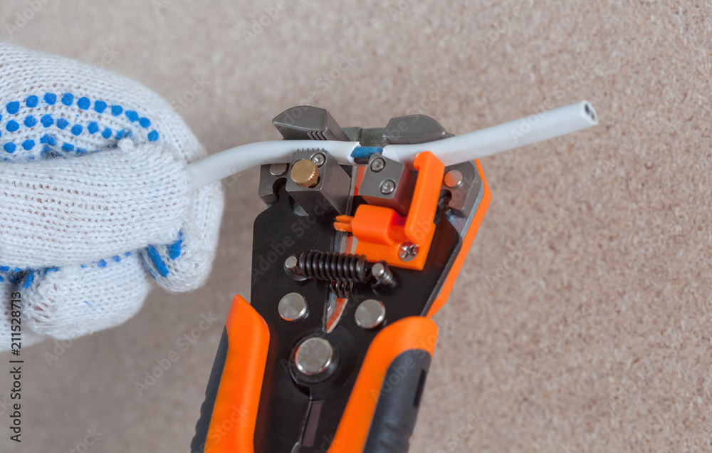 The electrician cuts the wire and runs the wiring in the building. The electrician cuts the wire and runs the wiring in the building.
