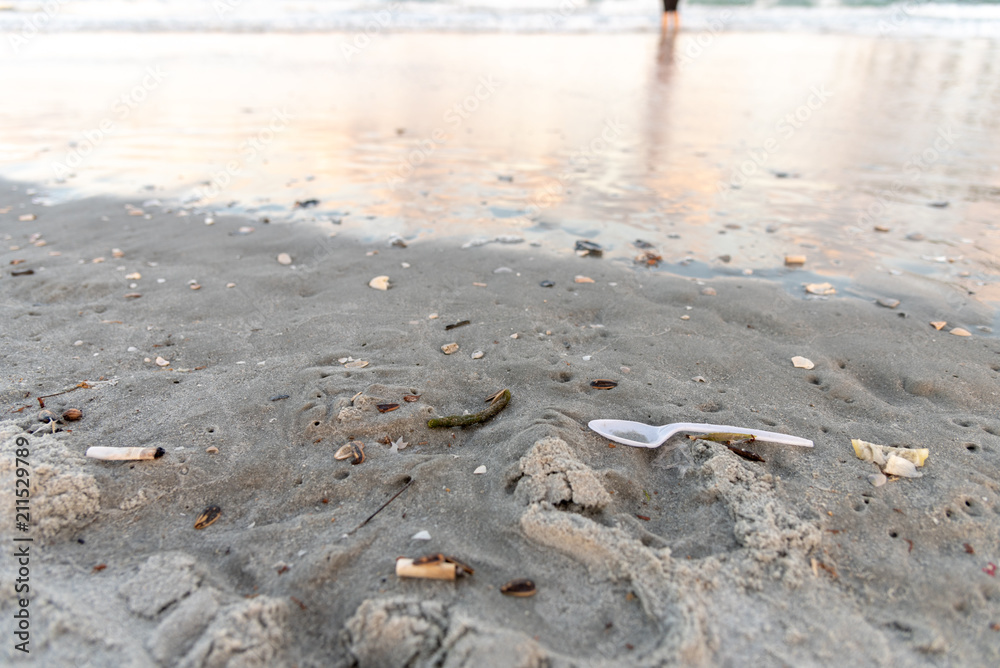 plastic spoon and cigarettes on the beach plastic spoon and cigarettes on the beach